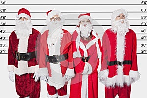 People in Santa costume standing side by side against police lineup