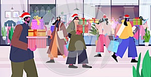 people in santa hats with gifts and shopping bags preparing for christmas new year sale holidays celebration concept