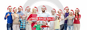 People in santa hats with sale sign at christmas