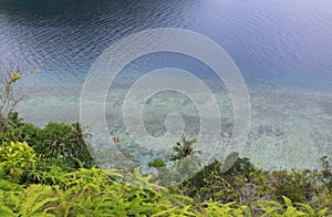 People in sea kayak on island coast tropical sea