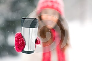 Hand holding tumbler or thermo cup in winter photo