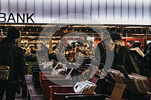 People at second hand book market in Southbank, London, UK, in the evening