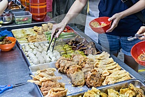 People selecting yong tau foo, delicious fried stuffed fish paste into chilli pepper, okra, aubergine, bean paste and