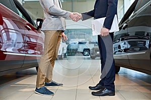 People Shaking Hands in Car Showroom