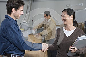 People Shaking Hands In Distribution Warehouse