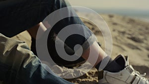 People shoes resting beach on sea sand. Romantic couple enjoy date at nature.