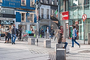 People shopping on Oliver Plunkett St, one of the city`s main streets for stores, street performers, restaurants, and busy city.