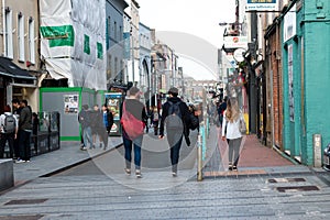 People shopping on Oliver Plunkett St, one of the city`s main streets for stores, street performers, restaurants, and busy city.