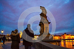 People sightseeing at picturesque Charles Bridge Prague at night