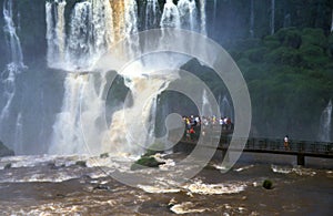 People on a sightseeing platform in front of the roaring waterfalls of Ignazu, Argentinia