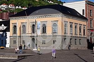 People sightseeing and walking around the Norges bank, Norway's central bank in downtown Bergen