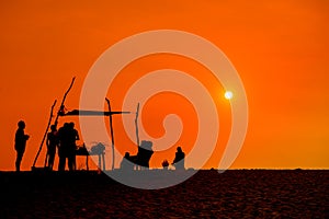 People silhoettes at sunset on a beach