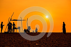 People silhoettes at sunset on a beach