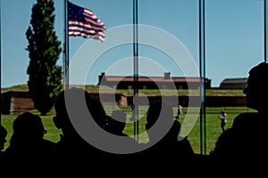 People silhouettes at fort mchenry baltimore usa flag while waving