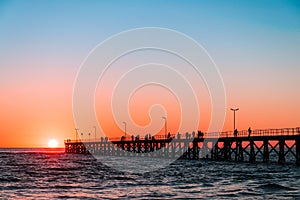 People silhouettes on Port Noarlunga jetty at sunset