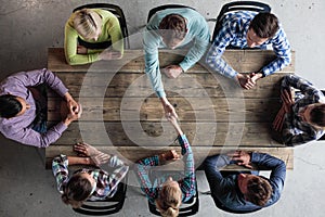 People sitting around table giving high five