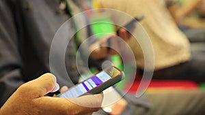 People sitting at business conference, man with smartphone in hands