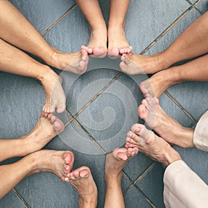 People Sitting in a Circle with Feet Touching