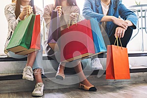 People sitting and holding shopping bags together