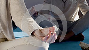 People sitting in lotus position on floor in yoga studio