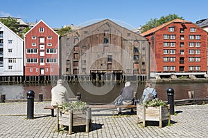 People sitting by Nidelv river Trondheim