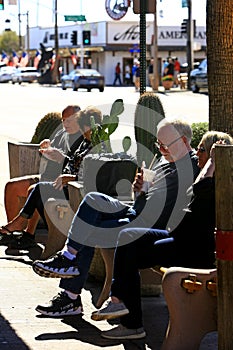 People sitting on a sidewalk bench enjoy the delights of a milkshake in Scottsdale AZ