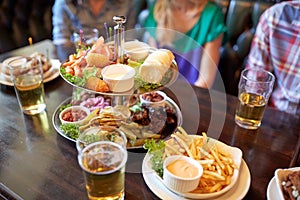 People sitting at table with food and beer at bar