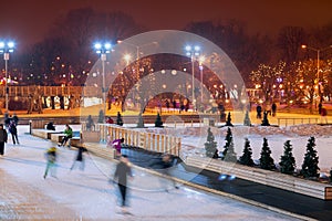 People skate in the evening in the Park in winter.