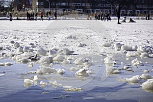 People skating on thin ice in the middle of a neighborhood. It is unsafe at the edge