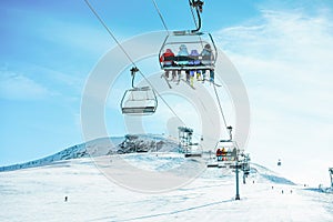 People on ski lift in winter resort - Holidays, snow gear renting, skiing, snowboarding and mountain landscape concept - Focus on