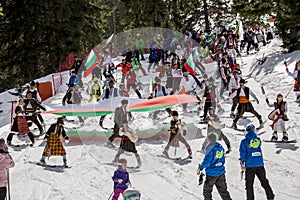 People skiing dressed with traditional bulgarian clothes.