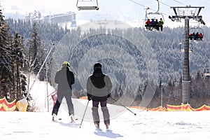 People skiing on snowy hill in mountains. Winter