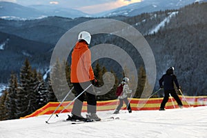 People skiing on snowy hill in mountains. Winter