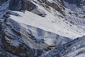 People on the slope of snow-capped Seceda mountain in the Italian Dolomites in clear weather