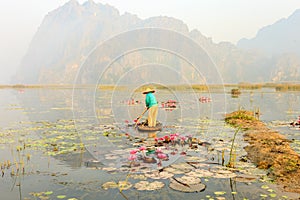 People with small boat on Van Long pond, Ninh Binh province, Vietnam