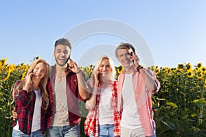 People smart phone call group friends outdoor countryside sunflowers field