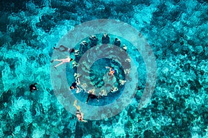 The people are snorkeling near the famous place on Gili Meno Island, Indonesia. Aerial view. Underwater tourism in the ocean. Gili