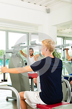 People in sport gym on the fitness machine