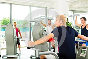 People in sport gym on the fitness machine