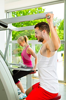 People in sport gym on the fitness machine