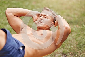 People, sport, lifestyle and endurance concept. Sporty young male bodybuilder with stong body, does crunches, has outdoor training