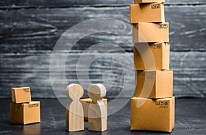 People stand and talk near the tower of cardboard boxes. Services for the transportation and delivery of goods. Online shopping