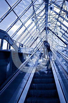 People standing on escalator in business center