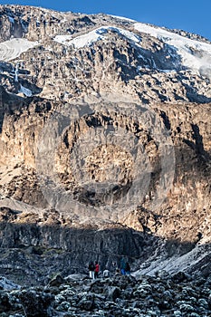 People standing before huge rock in mountain