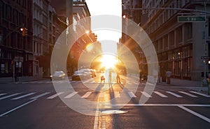 People standing in the middle of the intersection at 23rd Street in New York City taking pictures of the summer sunset