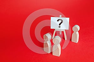 People are standing near the easel with a question mark. Asking questions, searching for truth. Curiosity, learn and improve