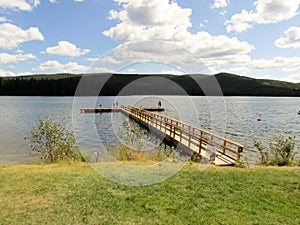 People standing on a pier in the lake at Lac Le Jeune provincial park, BC, Canada.