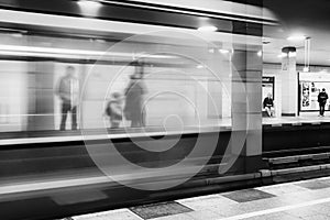 People standing at platform and blurred train coming to the subway station in city Berlin at Germany