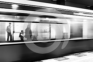 People standing at platform and blurred train coming to the subway station in city Berlin at Germany