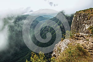 People on steep rocky cliff at Fortaleza Canyon